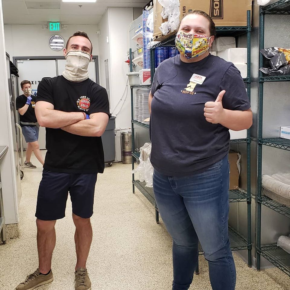 Old Town Pizza employees standing in the kitchen wearing masks to prevent the spread of Covid-19.