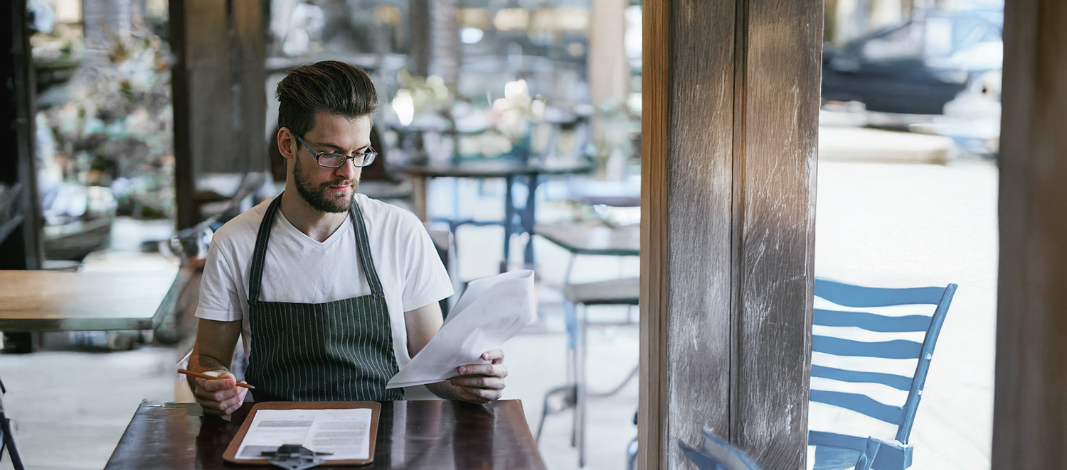 A man looking at the restaurant reports